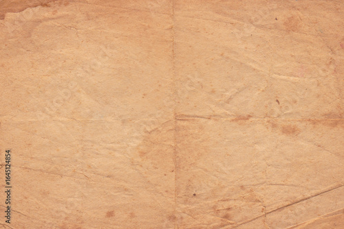 Aged Old Paper Texture Background. Rustic vintage paper folded in four. Brown crumpled and folded parchment vintage paper sheet with space for text