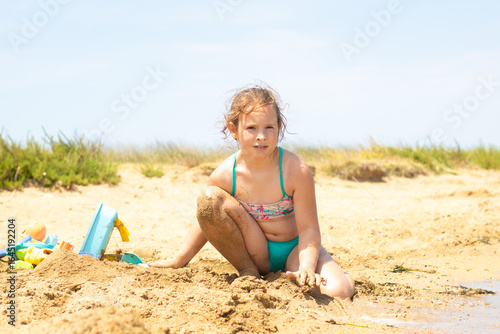 Young girl playing in the sand at the beach