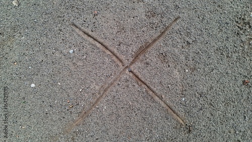 Cross Mark Sign Drawn on Ground Soil Surface, Symbol X Shape on Sand Texture Background for Warning, Direction, and Design Element Concept