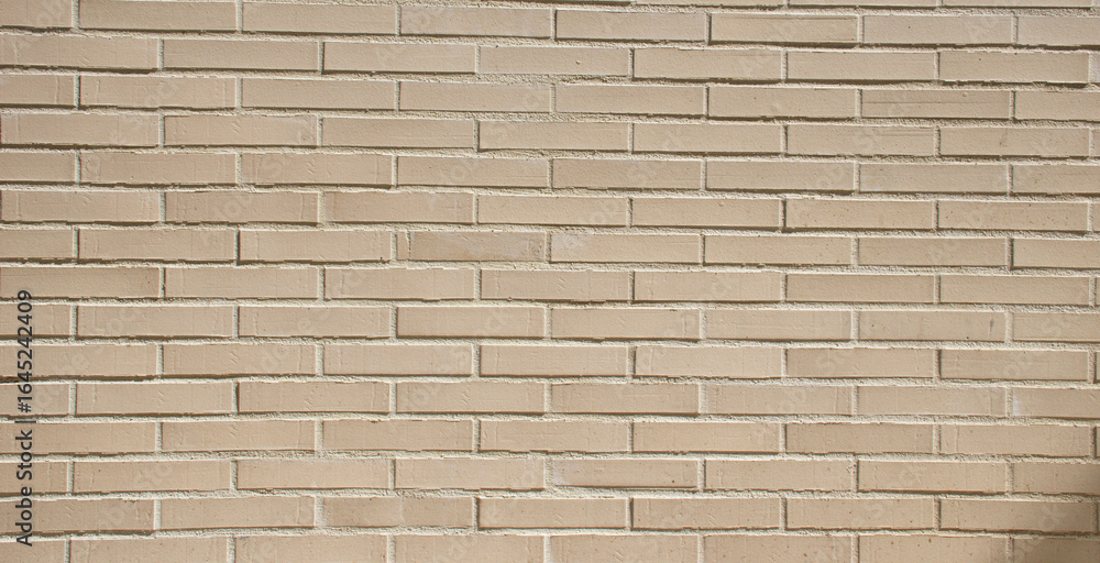 Fototapeta premium Small brick wall background, beige brick texture and masonry pattern, ideal for construction, architecture, and decorative design projects. this building wall with clean brick surface.
