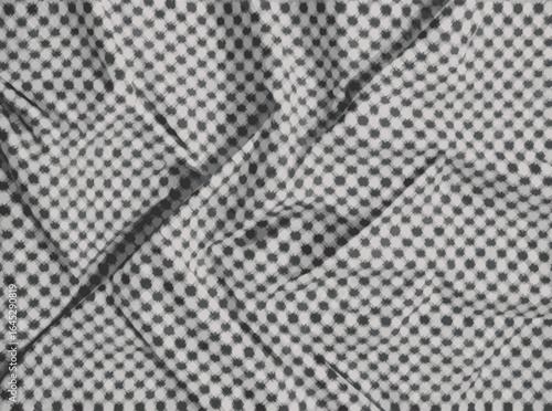 Close up of a textured fabric with a subtle checkered pattern and soft folds