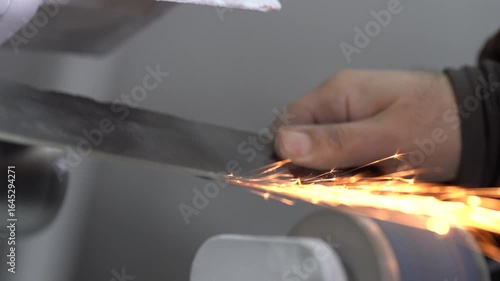Detail of a master sharpening a steel knife