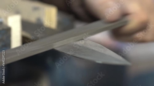 Detail of a master sharpening a steel knife