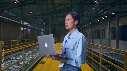 Wallpaper Mural Side View Of Asian Female Professional Worker, Inspecting Plastic Recycling Factory with Conveyor of Bottles, Observes By Looking Up Before She Come To Concentrating On The Laptop And Keep On Typing Torontodigital.ca
