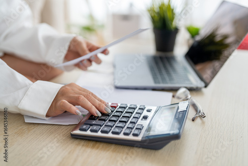 Human use calculator and calculate bills and paying bill, credit card, tax and vat, payment, concept of money management and business report with financial documents, financial accounting concept