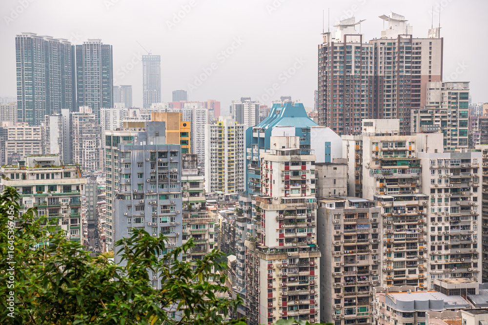 Obraz premium JANUARY 10, 2024, MACAU: Top view on the residential district of Macau behind the trees