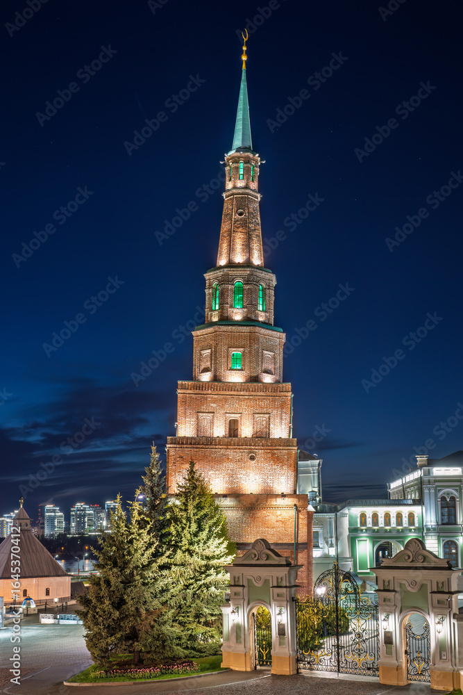 Fototapeta premium The ancient leaning red brick Syuyumbike Tower at night on the territory of the Kazan Kremlin. Russia