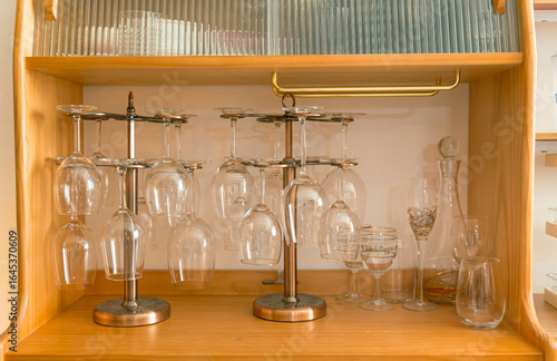 glasses on the wooden shelf, rack with many wine glasses, a corner in the home kitchen