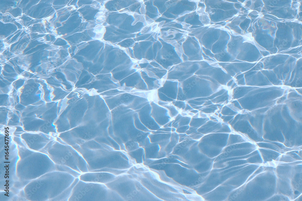 Obraz premium Clear blue water background, reflected ripple across the pool, top view of summer surface of swimming pool with sunlight, design for cosmetic product ,skincare wallpaper