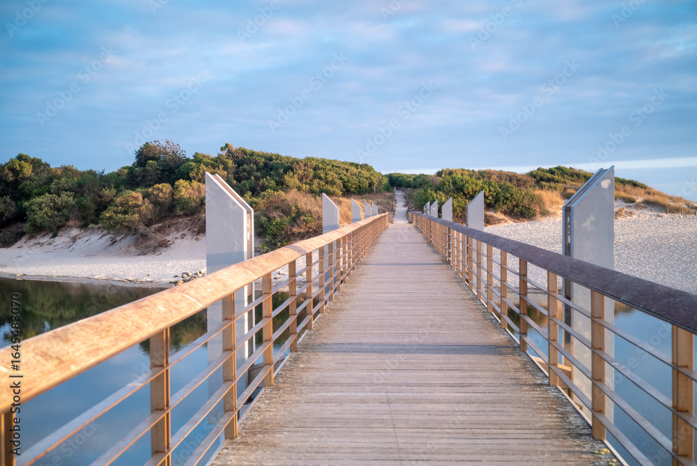 Fototapeta premium The perfect path for a walk in nature a modern wooden bridge over a lagoon summer vacation concept