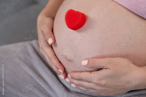 Wallpaper Mural Caucasian pregnant woman holding heart on belly background. Third trimester.  Torontodigital.ca