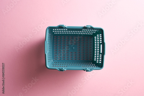 top view of  shopping basket against pink background.