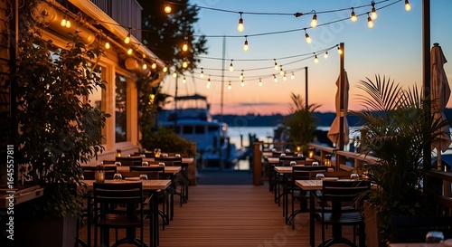 Outdoor restaurant patio with string lights and sunset over water