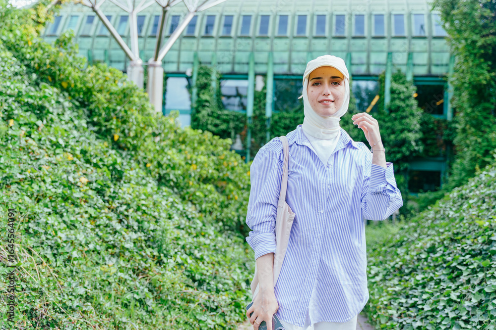 Obraz premium Turkish student in light hijab standing near university green facade