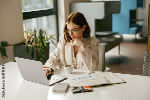 Foto A dedicated professional engrossed in their work at a desk, surrounded by a lapt