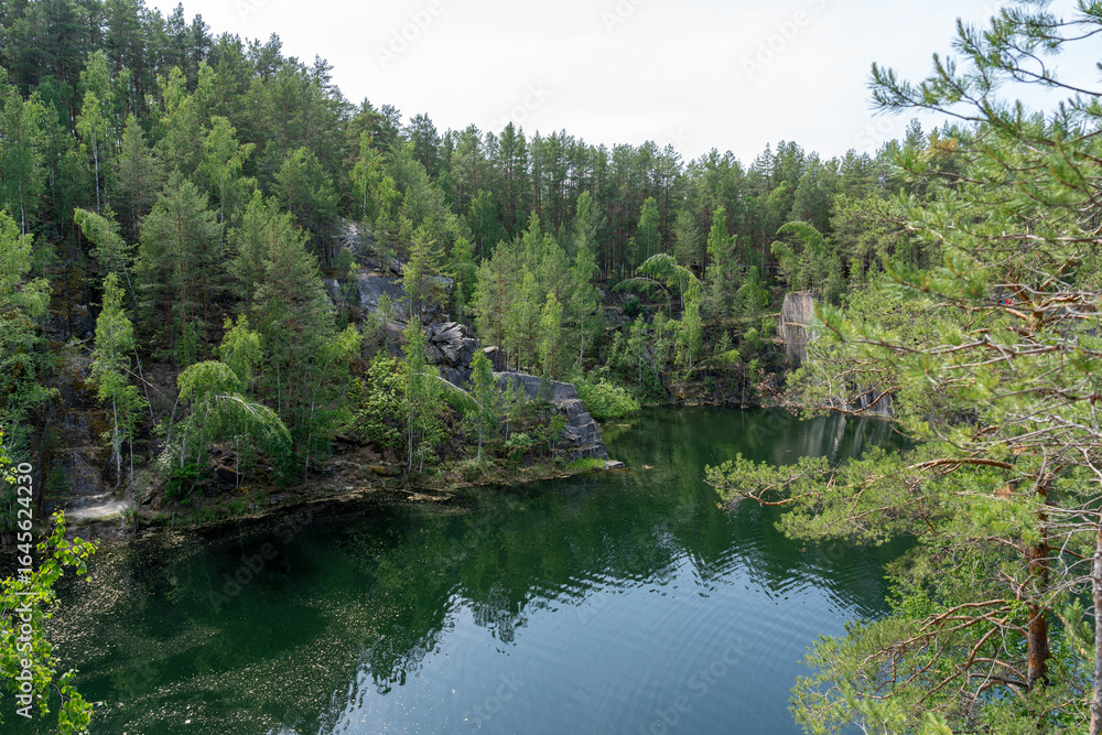 Fototapeta premium Talkov Kamen or Talkov Stone is flooded quarry that formed lake in Sysert district, Sverdlovsk region, Russia. Bazhovskie Places Natural Park. Abandoned talc mine