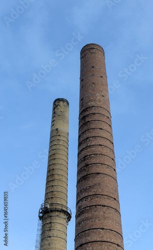 large old brick smoke stack smokestacks stacks for smoking factory refuse pollution cleanup rehabilitation abandoned disused industrial pipe tower tall sky clean dirty soot black chimney