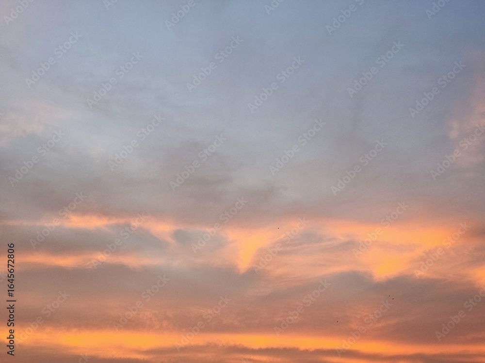 Obraz premium Peaceful evening sky with soft orange clouds during sunset