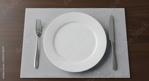 Elegant Table Setting with White Plate, Fork, and Knife on Textured Grey Placemats in Minimalist Dining Environment