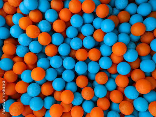 Blue and orange balls in a children's ball pit. Background. Example of the complementary colours blue and orange.