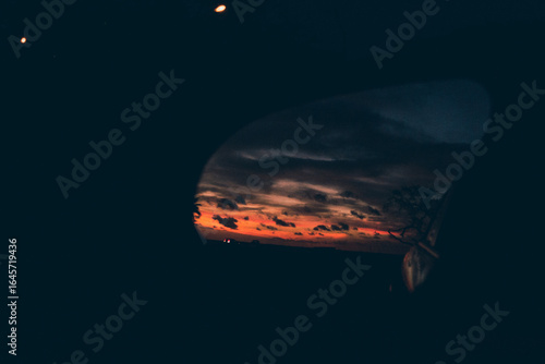 sunset in the rearview mirror during a scenic drive