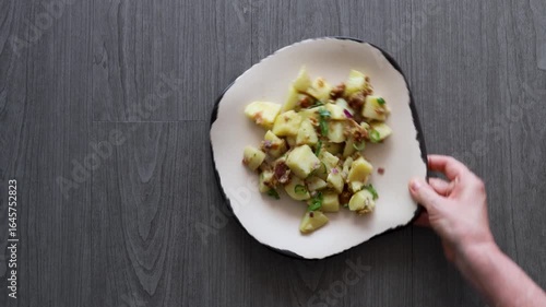 Serving a Plate of German Potato Salad with Bacon and Chives