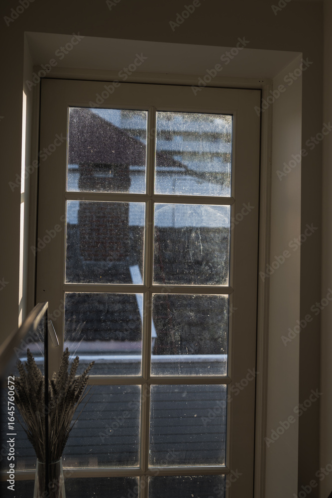 Fototapeta premium View Through a Window with Rooftops in Stavanger, Norway