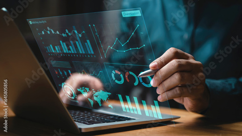 Modern business analyst reviewing data on futuristic laptop with glowing charts and graphs today