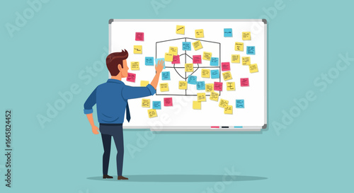 Businessman in a blue shirt and tie organizing colorful sticky notes on a whiteboard during a brainstorming session.