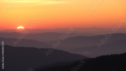 Wallpaper Mural Orange Sunset over Silhouetted Mountain Ranges Layers of hazy purple and dark silhouettes at dusk mountains Torontodigital.ca