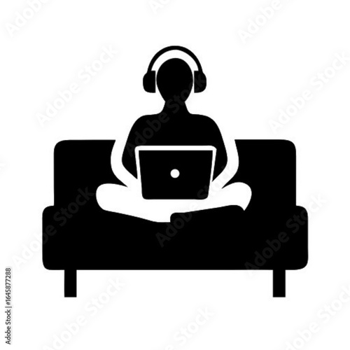 Person Working on Laptop at Home with Headphones on Couch Silhouette