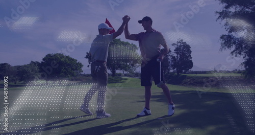 High-fiving golf friends celebrating successful putt on putting green, holding flagstick