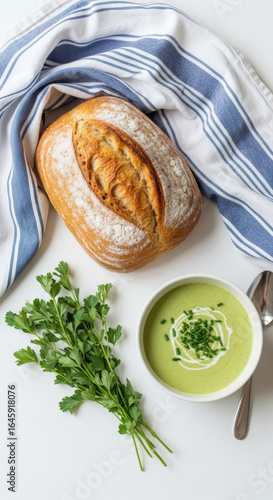 Deliciously creamy green vegetable soup served with crusty artisan bread and fresh herbs isolated on transparent background