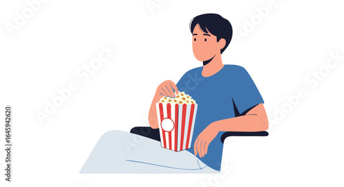 Young man engrossed in watching movie at cinema with striped popcorn bucket, experiencing immersive entertainment during leisure time