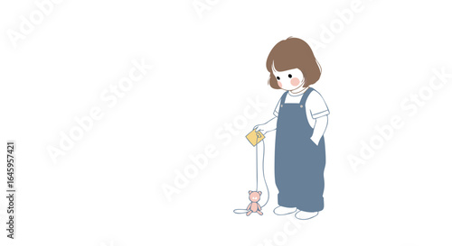 Charming young girl in overalls plays with a tiny plush toy, capturing sweet childhood innocence and joy