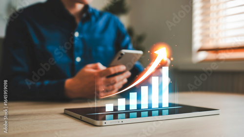A professional business analytics and data visualization image showing a digital holographic growth chart overlaid on a modern workspace