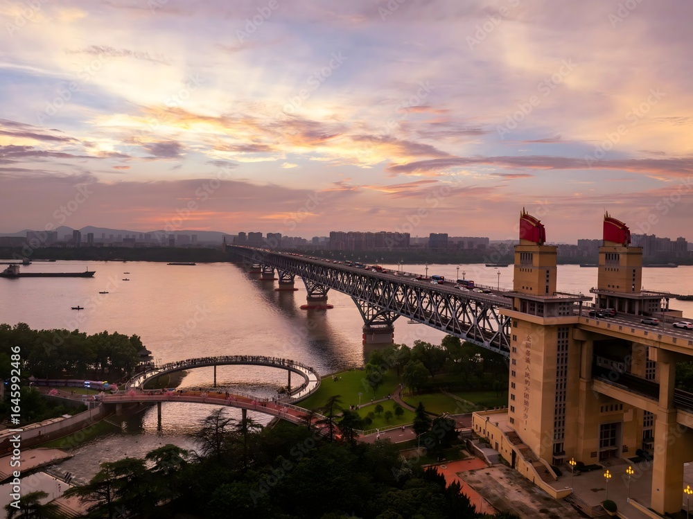 Obraz premium Nanjing skyline glowing under a warm sunset with rivers reflecting evening colors in a vibrant urban environment