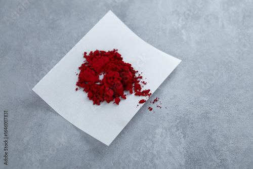 Powder of Allura Red AC, also known as FD&C Red 40. Food additive E129, azo dye commonly used in cosmetics, drugs, and food. Sample of controversial additive