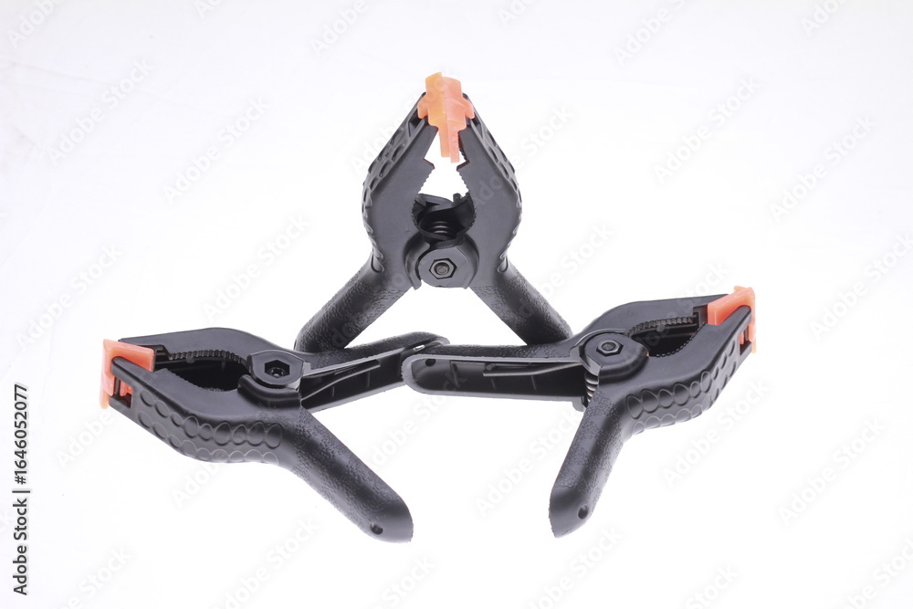 Obraz premium Black plastic spring clamps on a white background.
