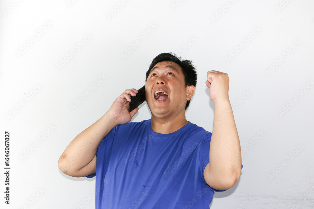 Fototapeta premium portrait of asian businessman talking on phone with winning gesture