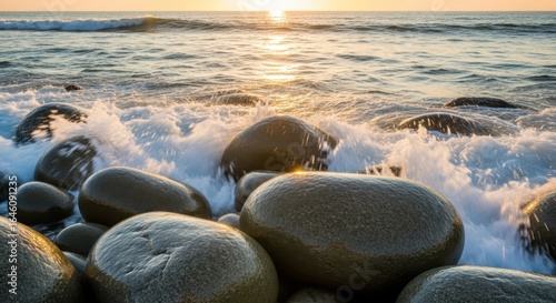 Ocean waves crashing over smooth wet rocks at sunset water