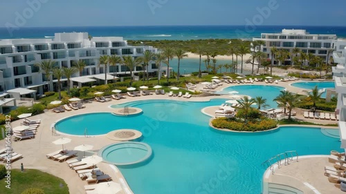 Escape to Paradise Dynamic video of Luxury Resort Pool beckons with turquoise waters, sunny skies, and swaying palms, perfect for travel ads, vacation promotions, and idyllic getaway campaigns