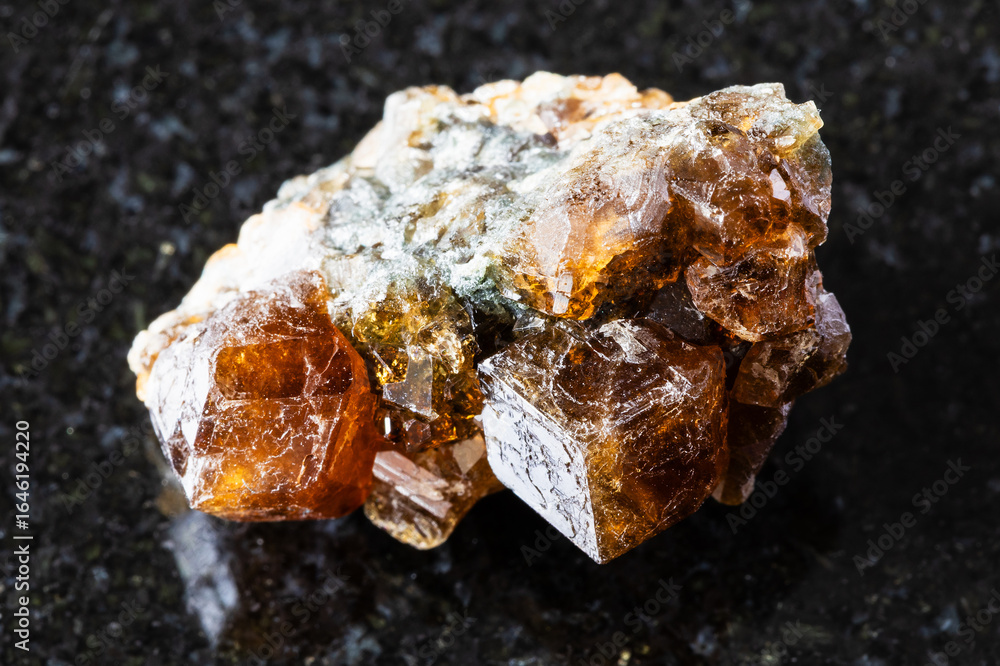 Fototapeta premium sample of raw hessonite grossular rock on black