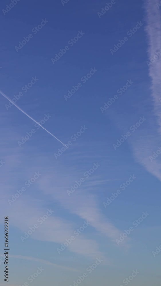 Passenger plane flying in the blue sky, fast transport leaves behind a white contrail trail. A trace of condensation trails or vapor trails, the aircraft engine exhaust. Passenger plane flying in the blue sky, fast transport leaves behind a white contrail trail. A trace of condensation trails or vapor trails, the aircraft engine exhaust.
