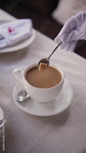 puts a sugar cube in coffee