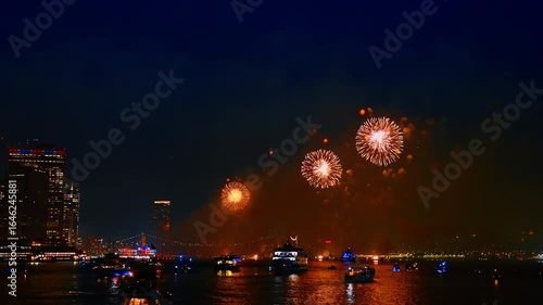 Stunning show with amazing fireworks over the East River in New York, USA. Multiple boats are standing on the river.