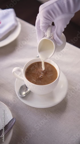 Pouring cream into black coffee
