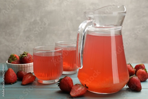 Quadro su tela Tasty compot in glasses, jug and fresh strawberries on light blue wooden table,