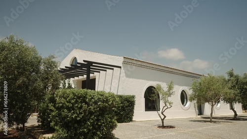 White Mediterranean-style building with circular windows and olive trees in Algarve, Portugal