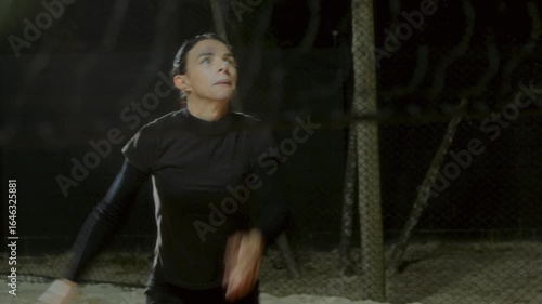 Volleyball Player in Black Sportswear Reaching to Hit Ball on Sand Court at Night